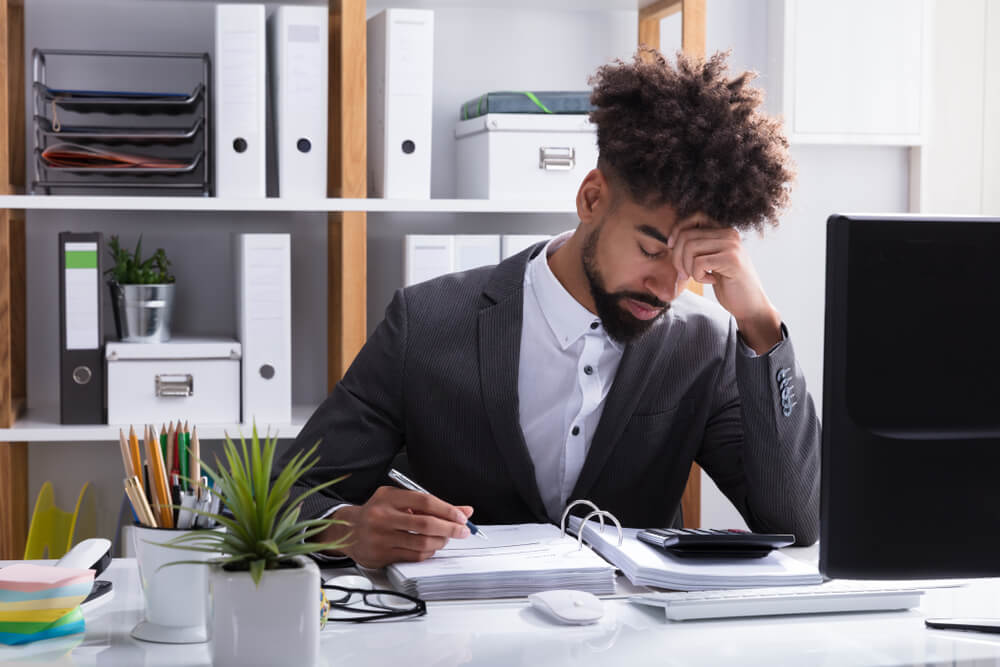 Unhappy Young Businessman Calculating Bill in Office